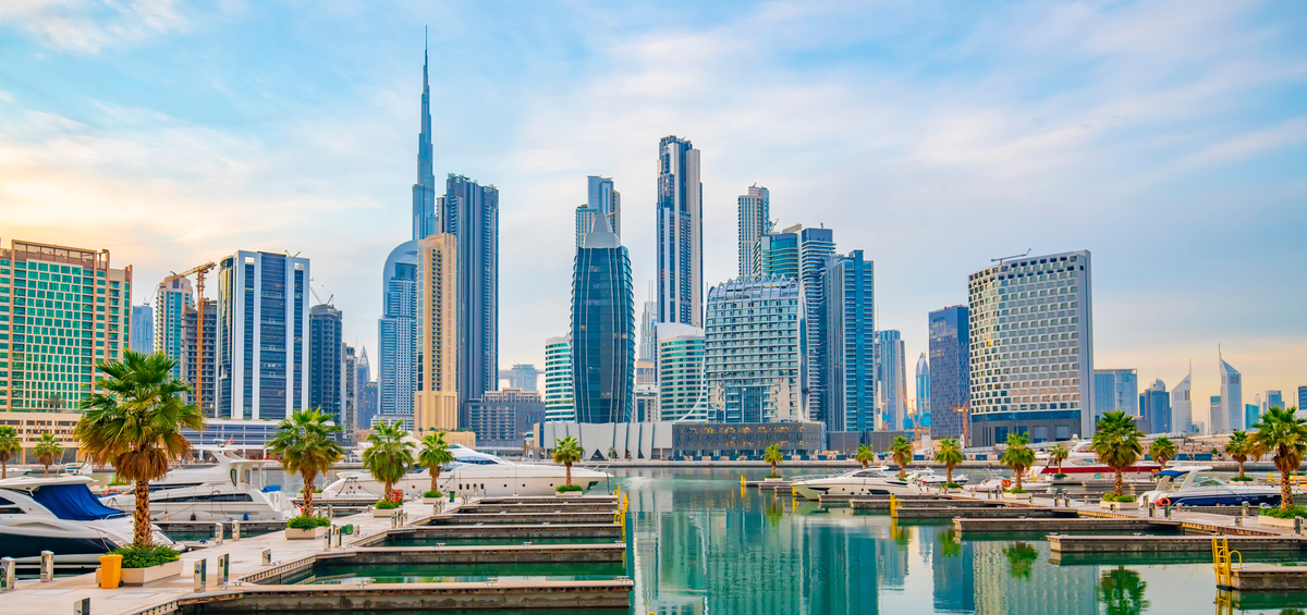 Dubai city skyline with modern skyscrapers and a marina.